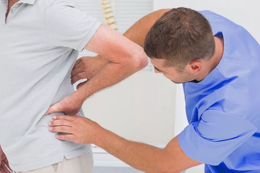 A patient with lower back pain at diagnostic examination by a doctor